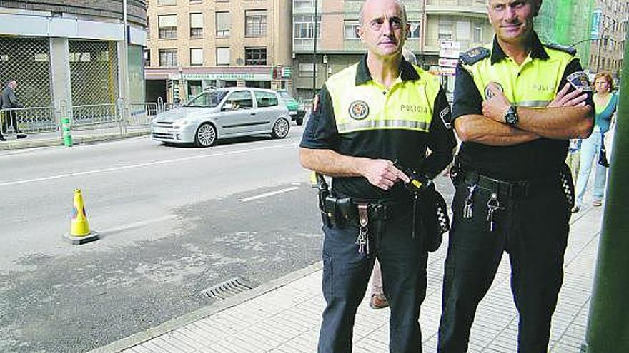 Los policías José Antonio Fernández, con una Taser, y Celestino Álvarez, ayer, en Posada.