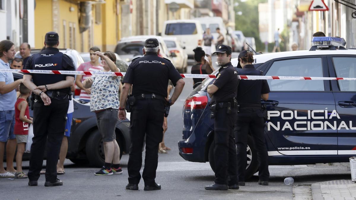 Agentes de policía y vecinos, frente al domicilio donde un hombre ha matado a su expareja, en Sevilla.