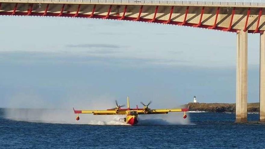 Un avión carga agua bajo el puente entre Ribadeo y Asturias. //Facebook Ribadeo