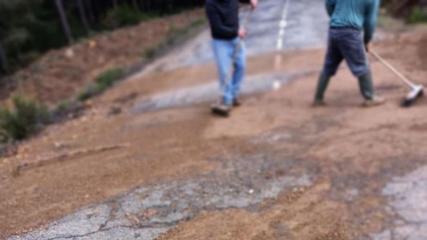 Los vecinos limpian de tierra la carretera de Escuredo. | A. S.