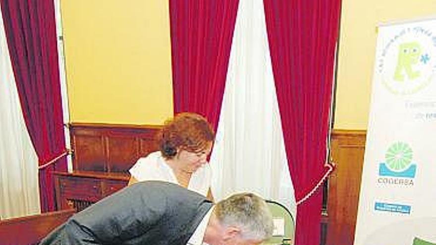 Santiago Fernández y María Inés Fernández manipulan el compostador.