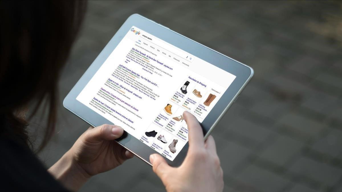 Una persona mira en una tableta entradas y fotos de Google