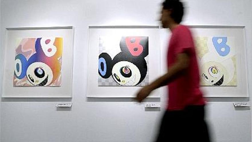 Un hombre pasa ante algunas de la obras de Murakami en La Llotgeta.