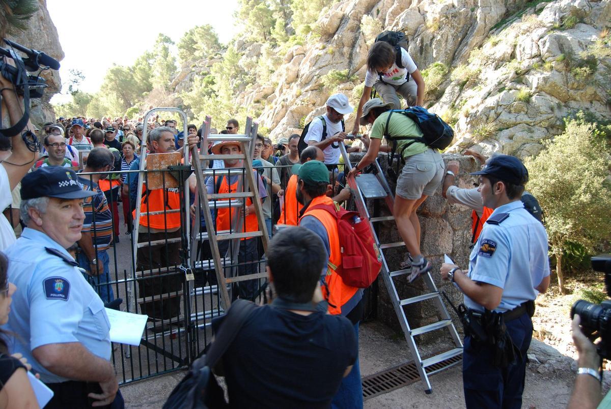 Manifestantes saltan la barrera del camí de Ternelles (Pollença), en una histórica marcha celebrada en 2011.