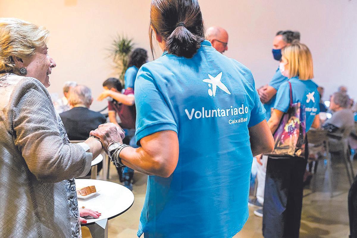 Una integrante de Voluntariado Caixabank realiza una actividad solidaria con personas mayores