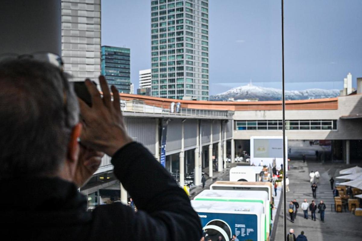 Asistentes al Mobile World Congress toman fotos de la nieve que ha caído esta mañana en Barcelona y ha cubierto de blanco Collserola