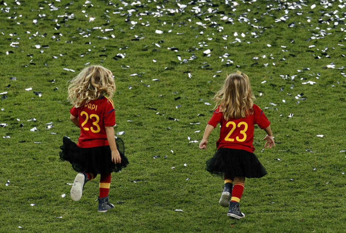Las hijas de Pepe Reina, con la camiseta del papi, corren por el terreno de juego.