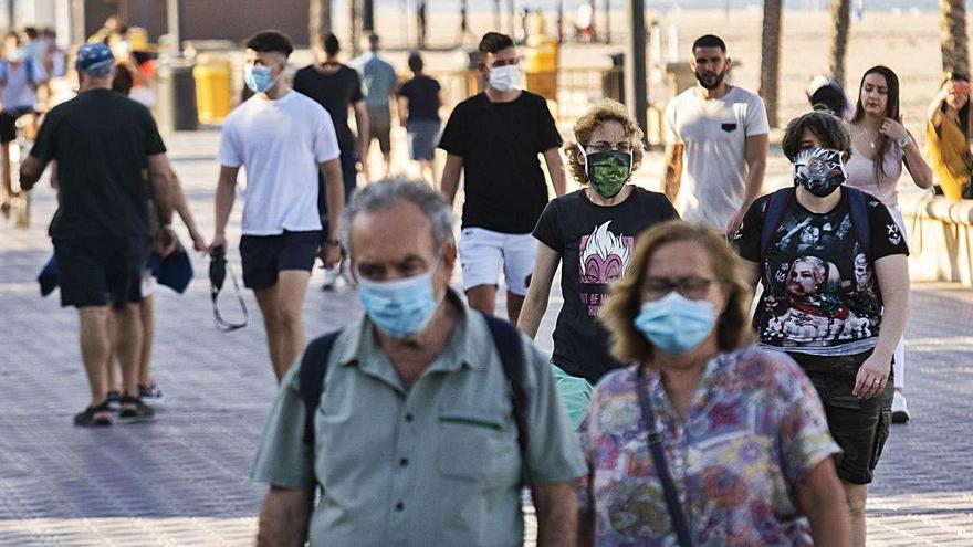 Varias personas con mascarilla en el paseo marítimo de la Malva-rosa, ayer.