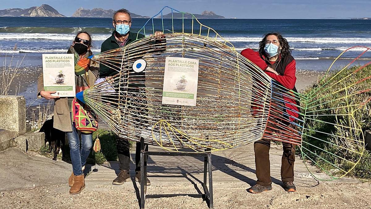 Alcalde y responsables del colectivo ecologista Amigos da Terra, con el “pez tragaplásticos” en Patos.