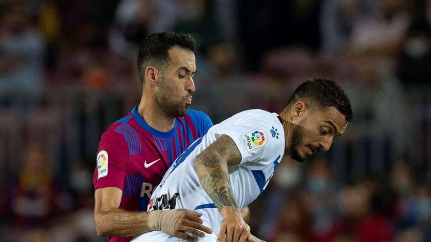 Joselu controla un balón de espaldas ante Sergio Busquets. // EFE