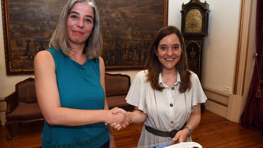 La portavoz de Marea, María García, y la alcaldesa, Inés Rey, se dan la mano, hoy, en María Pita tras firmar el acuerdo