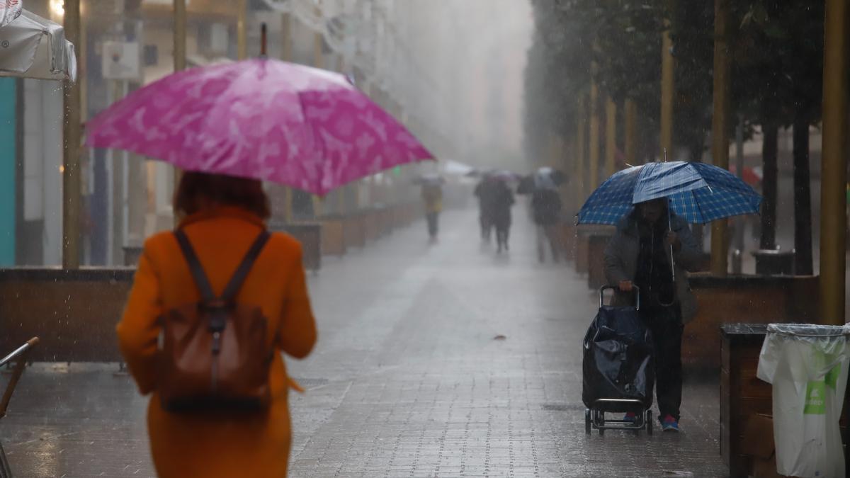 Varias personas se refugian bajo el paraguas en una jornada lluviosa en Córdoba.