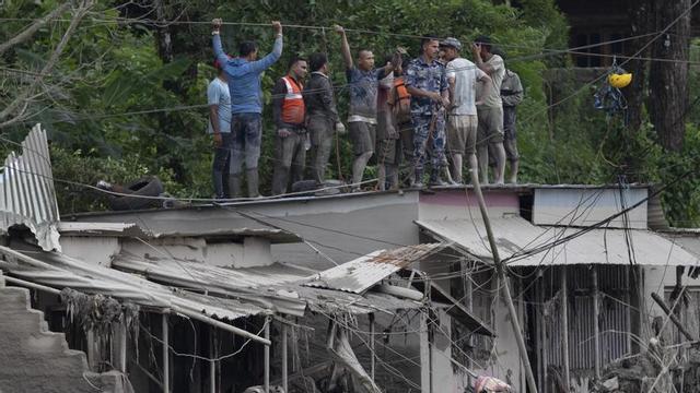 Equips de rescat en un terrat envoltats de l’aigua de la riuada, ahir al districte de Nuwakot (Nepal). | NARENDRA SHRESTHA / EFE