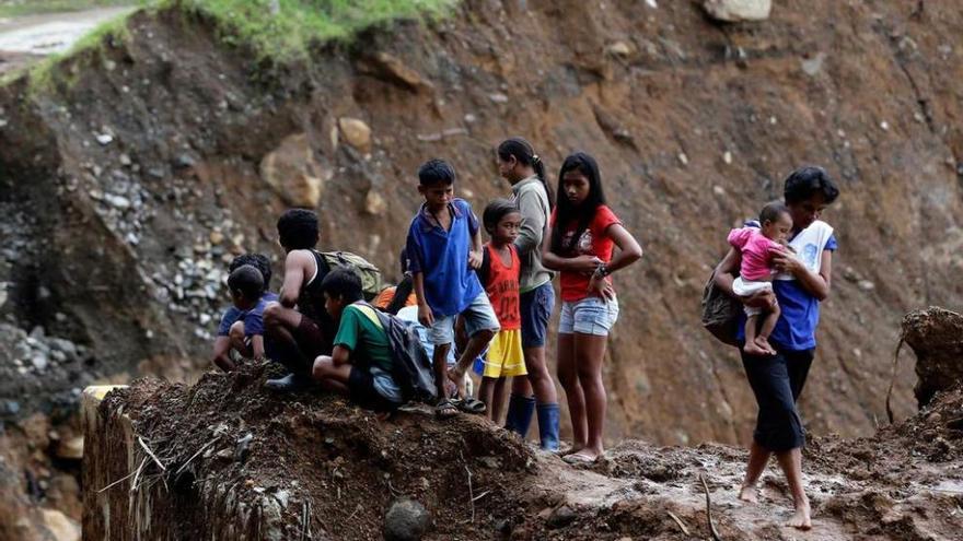 Un grupo de jóvenes, en una de las carreteras destruidas por el &quot;Melor&quot;.