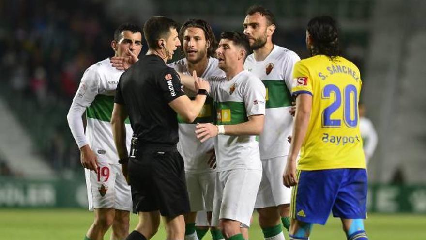 Los jugadores del Elche protestan la expulsión de Juan Cruz frente al Cádiz.