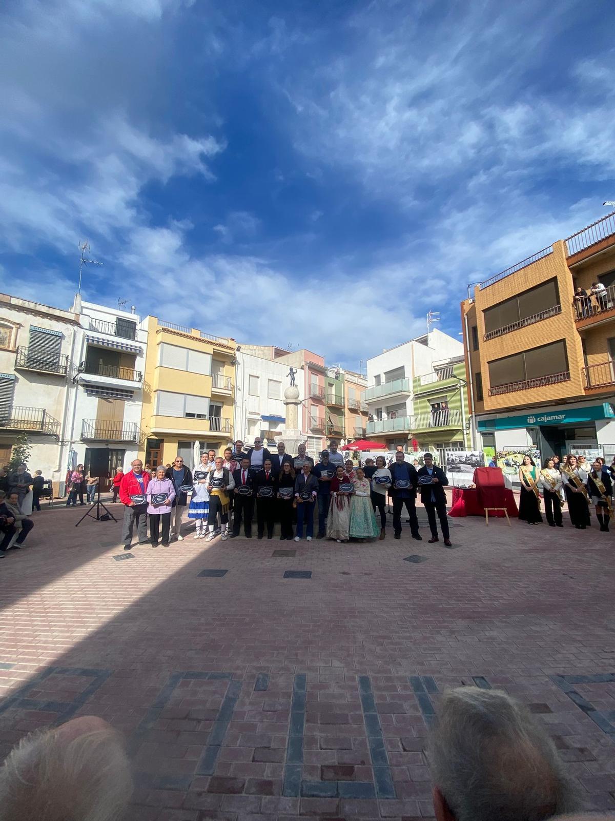 Foto de familia del acto de la inauguración de la Plaça Raval en Traiguera, en la que el Ayuntamiento entregó a cada asociación una réplica de la placa que hay grabada en el suelo y que homenajea a cada entidad.