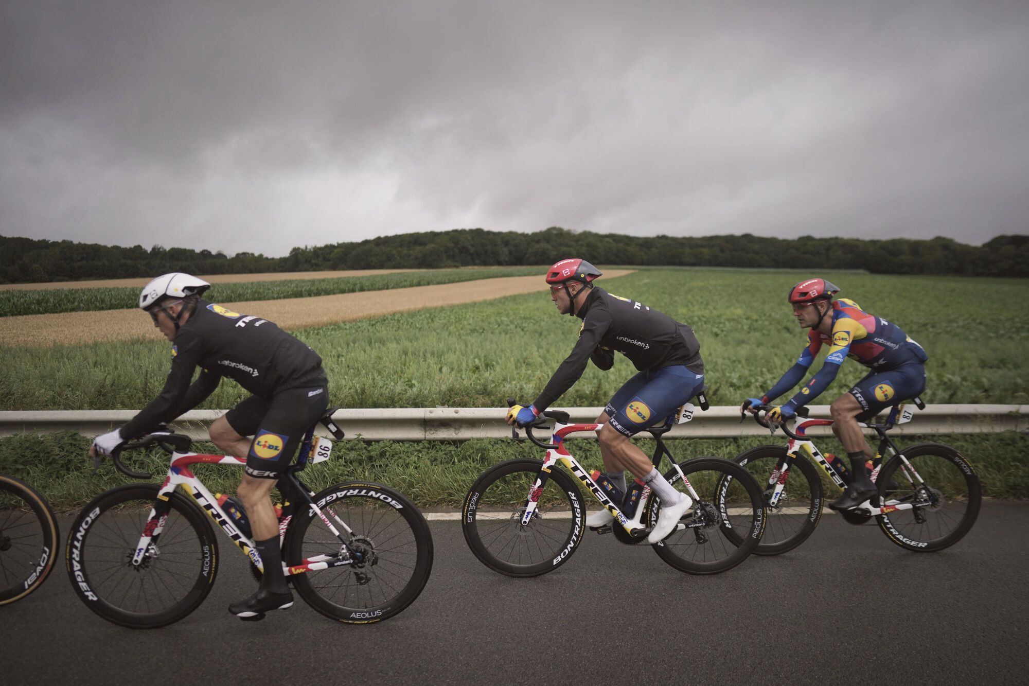 Latvia's Tom Skujins, left, Italy's Jonathan Milan, center, and Belgium's Jasper Stuyven ride during the second stage of the Tour de France cycling race over 209.1 kilometers (129.9 miles) with start in Lauwin-Planque and finish in Boulogne-sur-Mer, France, Sunday, July 6, 2025. (AP Photo/Thibault Camus)