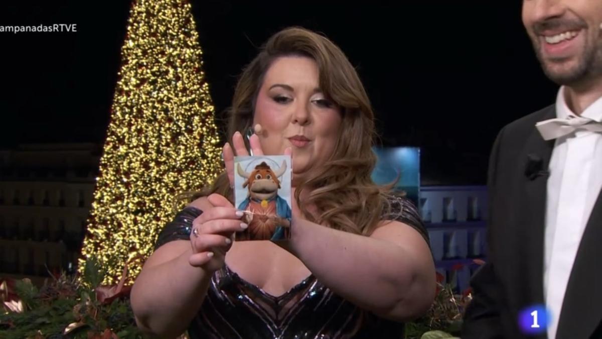 Lalachis, mostrando la estampita con la vaquilla del 'Grand Prix'.