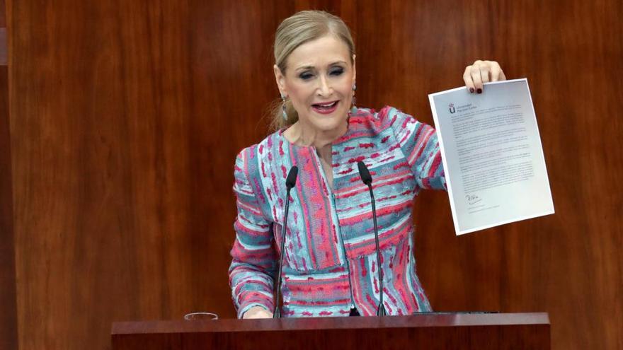 Cifuentes muestra un documento sobre su máster en la Asamblea de Madrid.