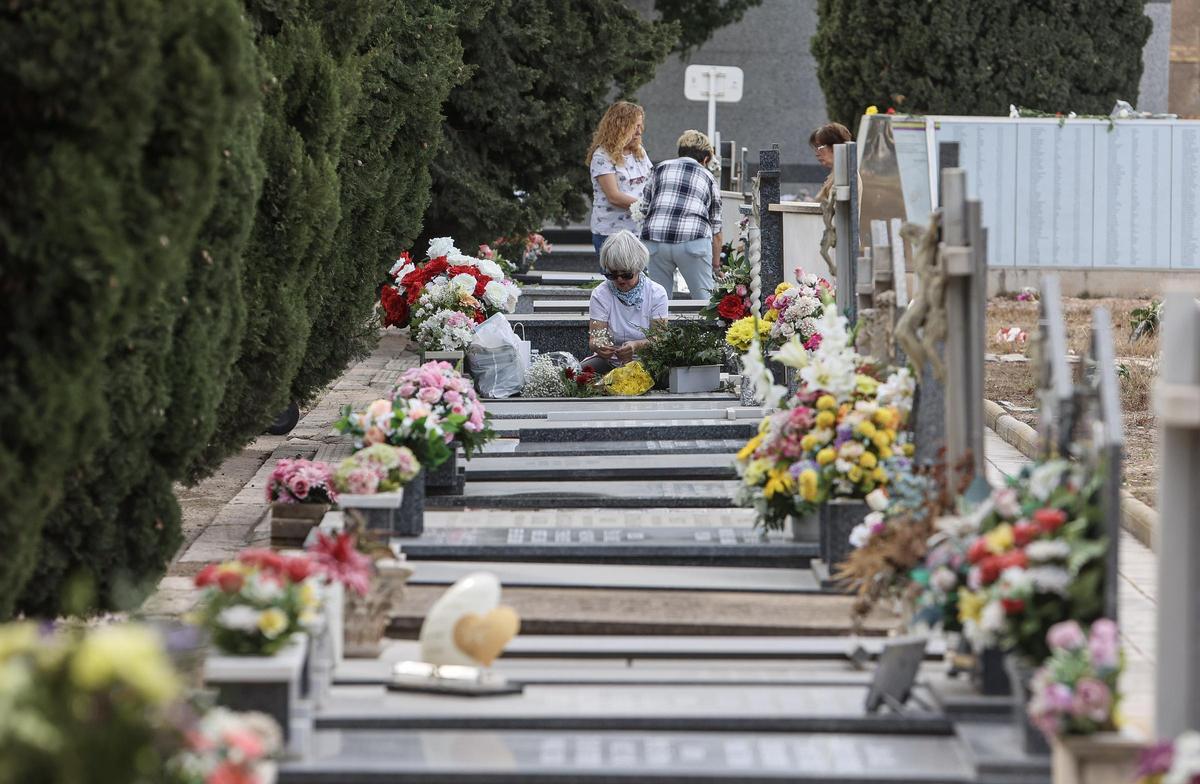 Una fila de lápidas decoradas con flores.