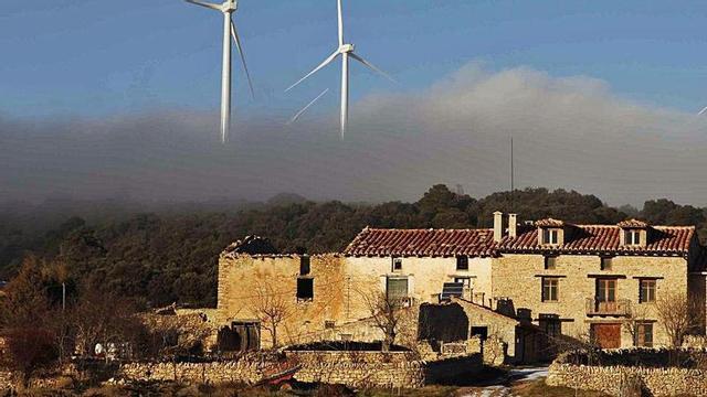 Una zona rural de Els Ports de Castelló con un parque eólico de fondo.