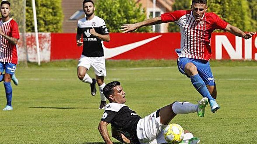 Dani Hernández se lanza al suelo para intentar robar el balón de los pies de un jugador asturiano.