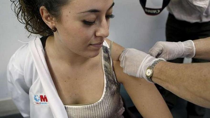 Una profesional sanitaria se vacuna contra la gripe A. / efe