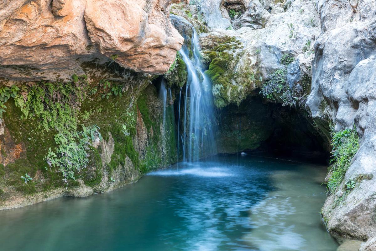 El contraste entre el color verde del entorno y el azul intenso del agua crea una estampa difícil de olvidar.