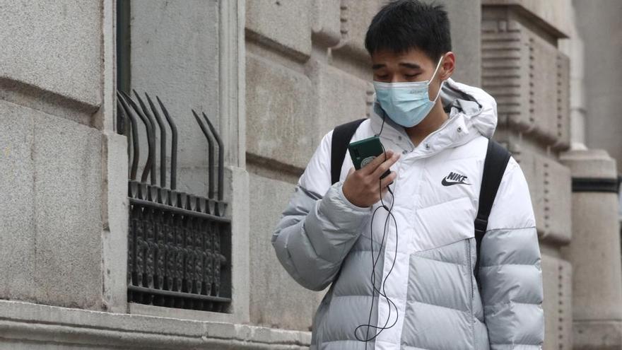 Un joven pasea con un mascarilla en Madrid.