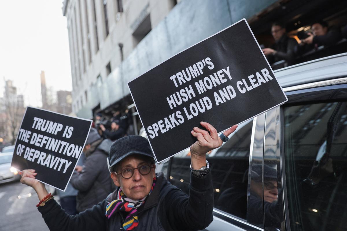 Una manifestante anti-Trump sostiene carteles frente al Tribunal Penal de Manhattan.