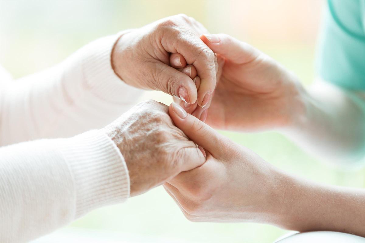 Una infermera agafa les mans d'una persona gran diagnosticada amb Parkinson