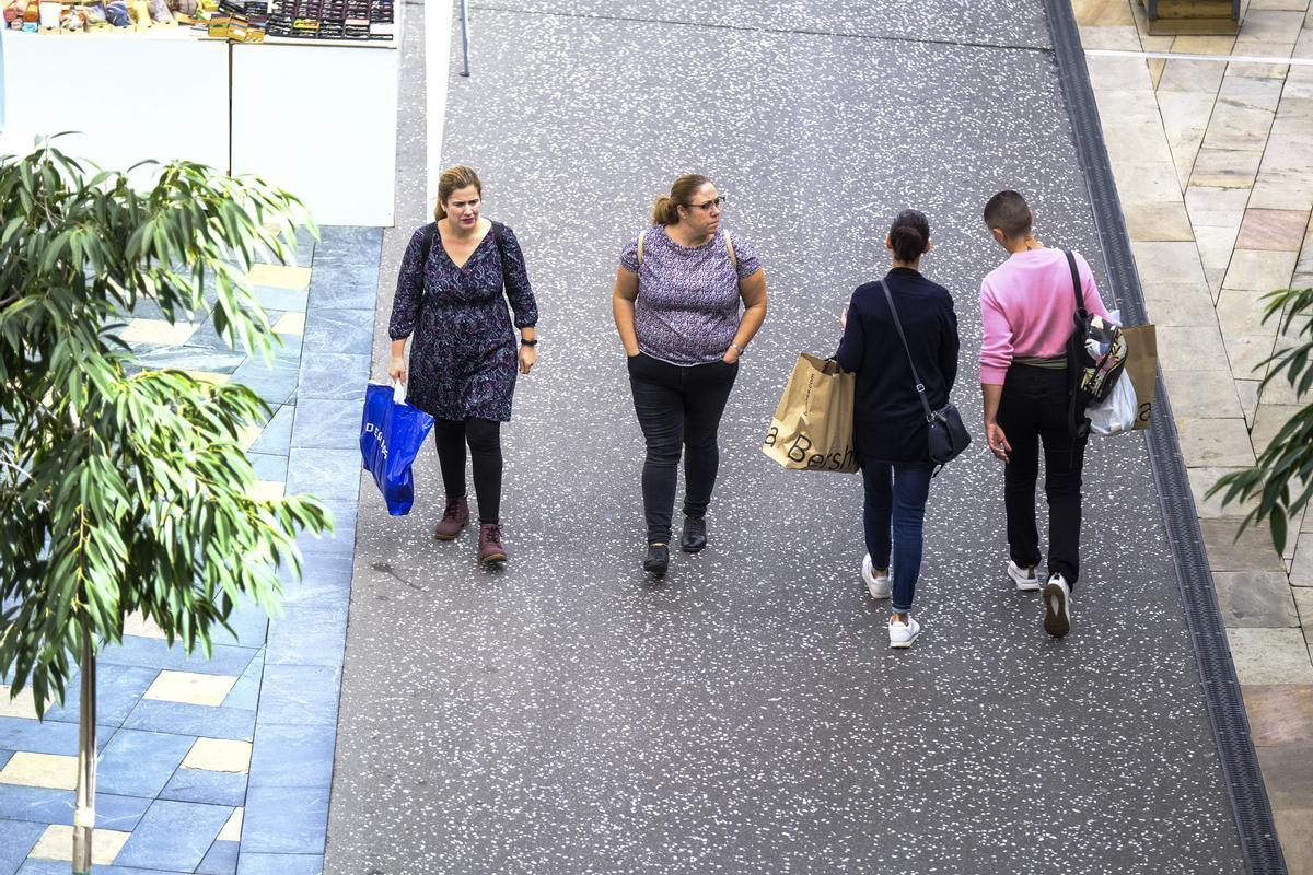 Gente pasea, con algunas bolsas en las manos, por el centro comercial Alisios