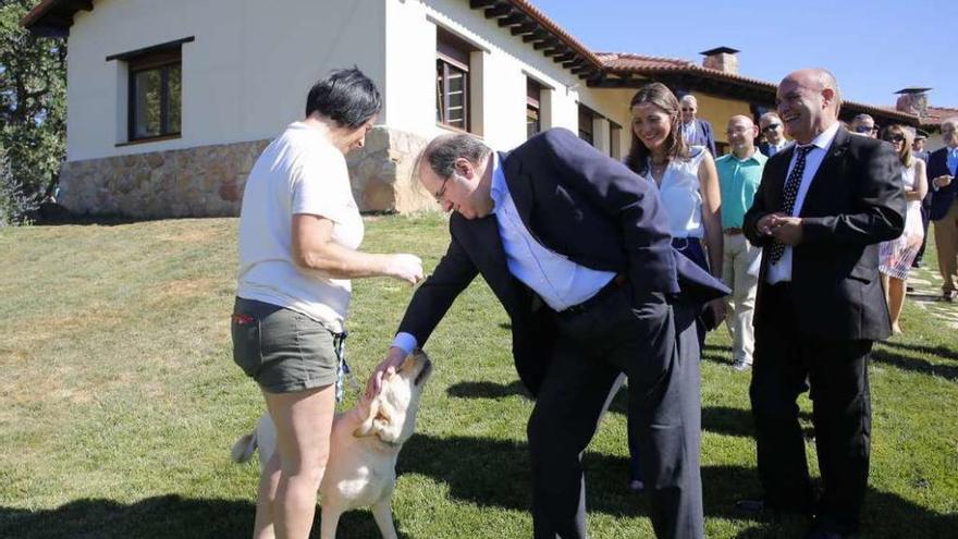 El presidente de la Junta acaricia un perro durante la inauguración del centro.