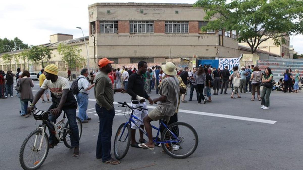 Ciudadanos concentrados ante la nave de Poblenou en la que residen 300 inmigrantes, este lunes.