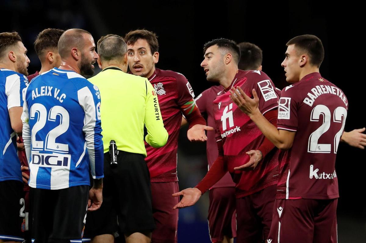 BARCELONA, 28/11/2021.- El colegiado Mateu Lahoz ante las protestas de los jugadores de la Real Sociedad y del Espanyol, durante el encuentro correspondiente a la decimoquinta jornada de primera división disputado hoy domingo en el RCDE Stadium, en Barcelona. EFE / Andreu Dalmau.