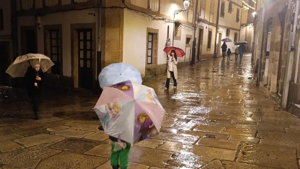 Viandantes con paraguas en la Ciudad Vieja de A Coruña.