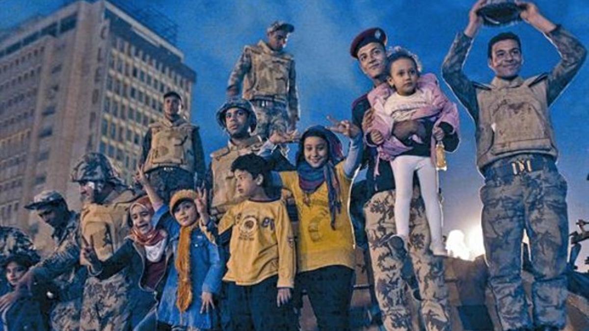 Soldados egipcios celebran con niños en sus brazos, en la plaza Tahrir.