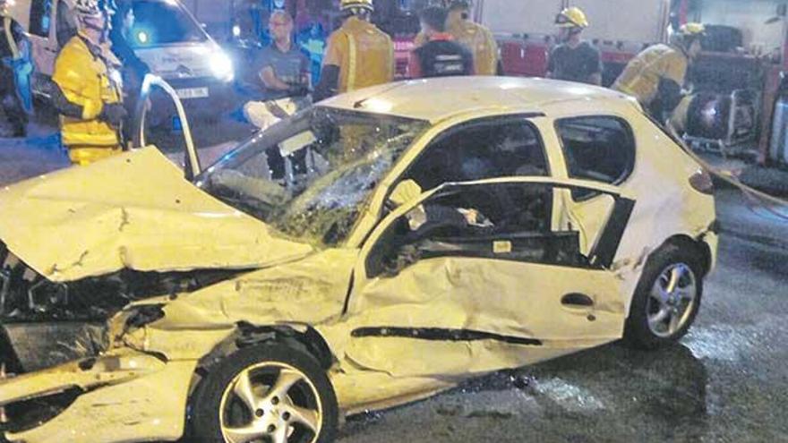 Un grupo de bomberos junto a un coche accidentado en el Paseo Marítimo de Palma.