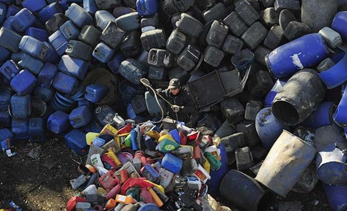 Un treballador descarrega ampolles de plàstic d’un camió en un centre de reciclatge als afores de Shenyang (Xina). Algunes ciutats xineses no estan complint el repte del desenvolupament sostenible, i això representa un risc per a l’estratègia de Pequín de dependre de la urbanització massiva per impulsar el creixement econòmic.
