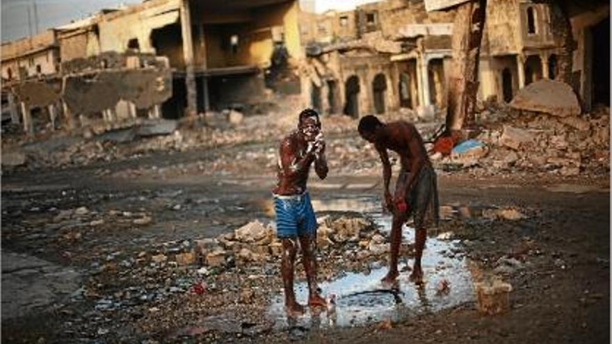 Dos nois es renten amb sabó i amb l&#039;aigua d&#039;una claveguera al centre de Port-au-Prince.