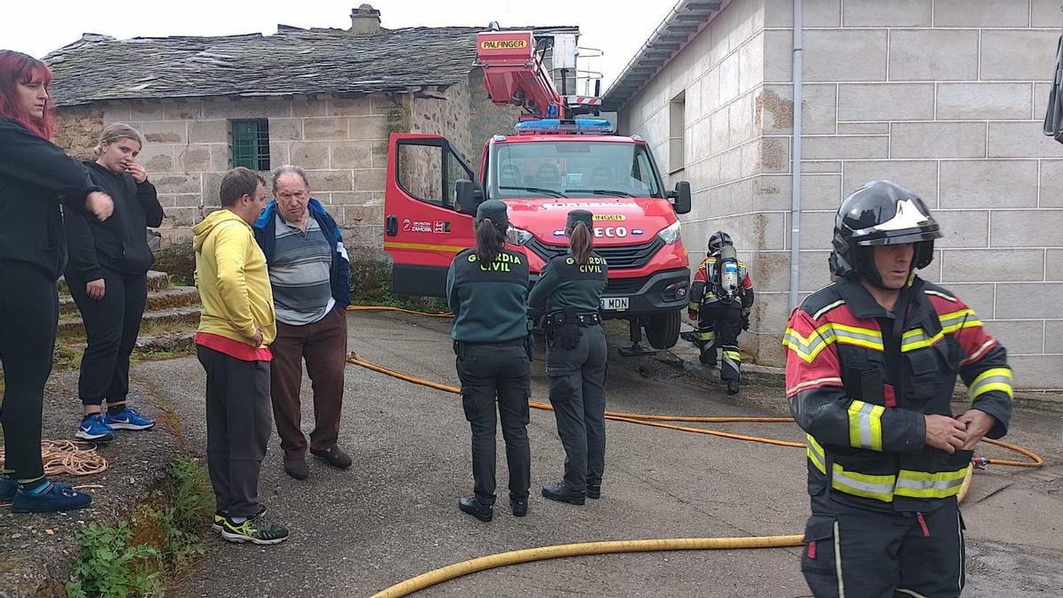 Vecinos, Bomberos y Guardia Civil en las inmediaciones del edificio que ha sufrido el incendio