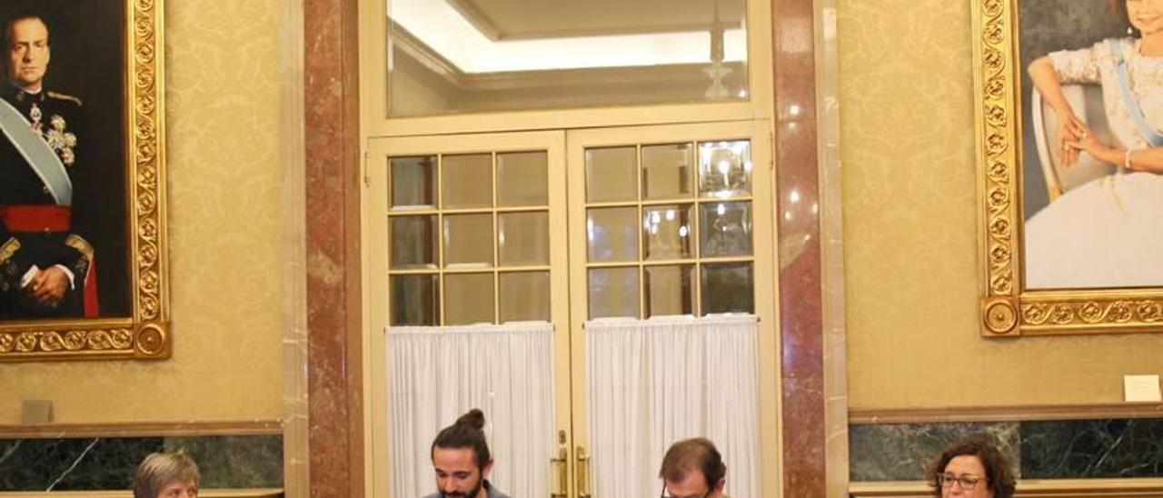 Picornell y el rector Huguet firmando el convenio con los cuadros de los Reyes detrás.