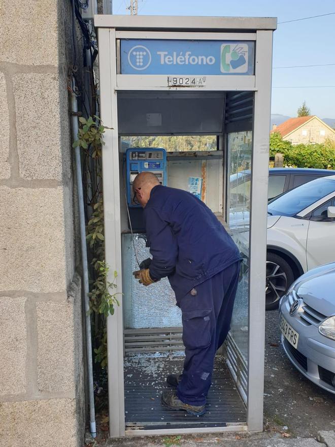 Un operario retira el teléfono de la cabina de Soutomaior.  // FdV