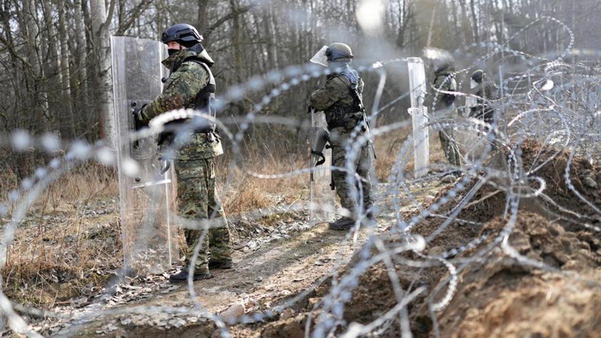 La policía de fronteras de Polonia monta guardia en la valla levantada en el límite con Bielorrusia, en febrero de 2022.