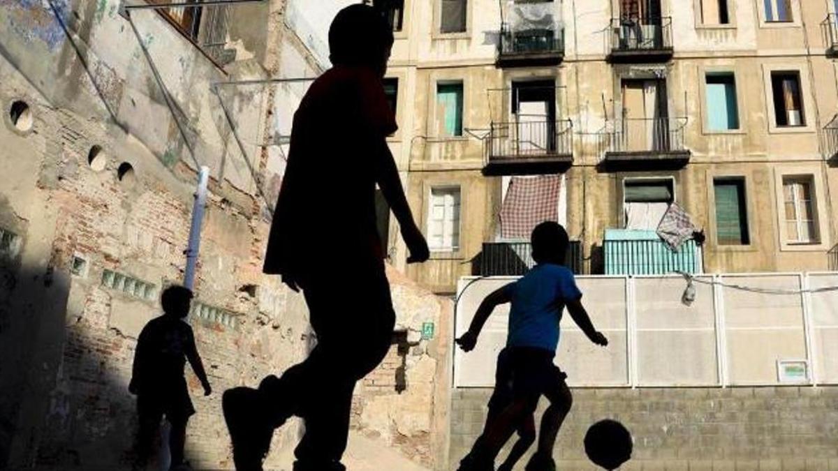 Unos niños juegan al fútbol en el Raval.