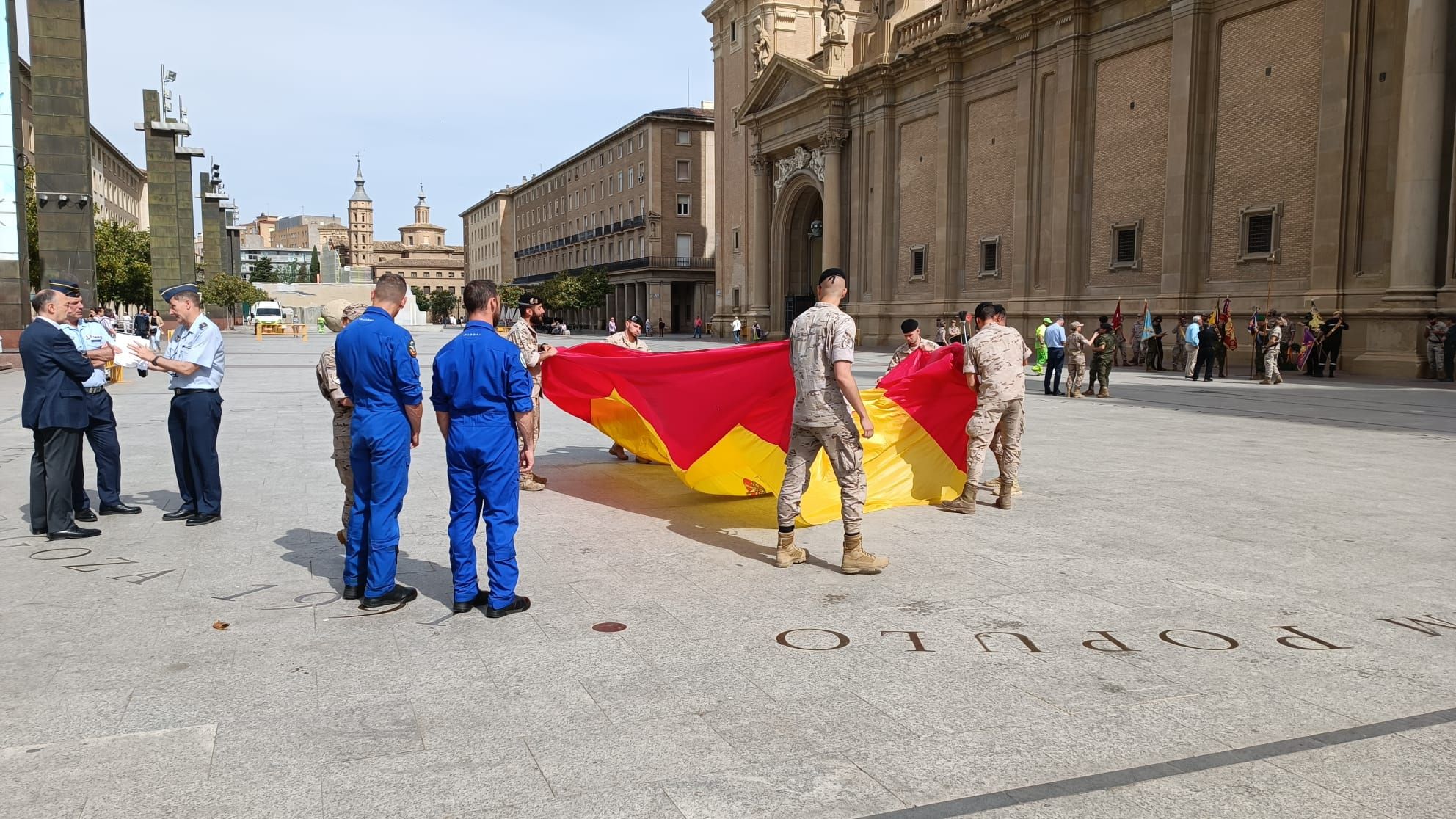 Preparativos para el despliegue aéreo de una bandera de España en la Plaza del Pilar