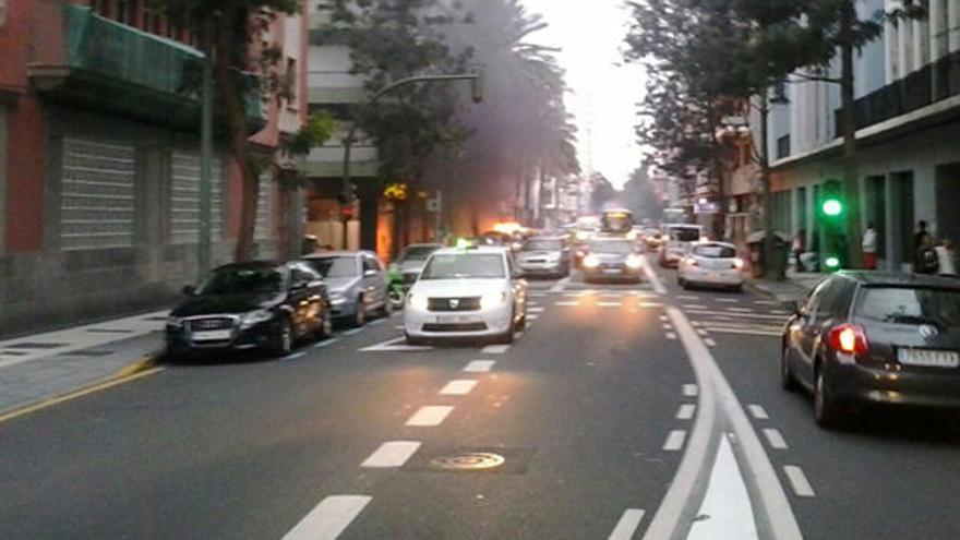 Un contenedor arde al fondo, en Primero de Mayo.