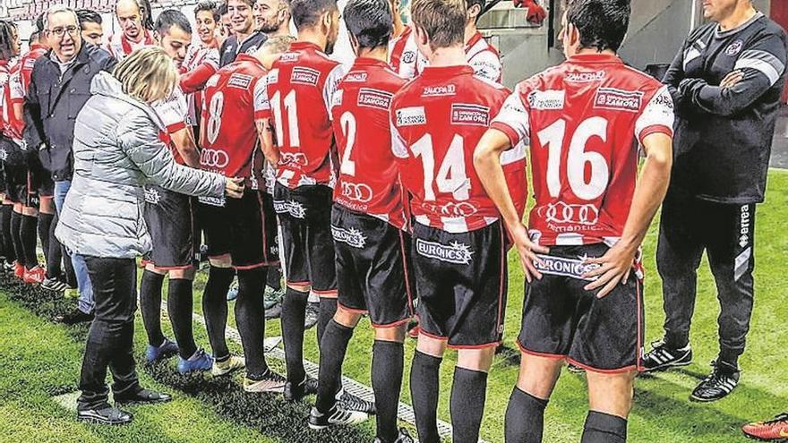 La presidenta Didia Liedo coloca las camisetas a los jugadores ante la mirada de Losada, a la derecha.