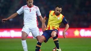 Xavi controla el balón en Montilivi ante Msakni, que marcó los tres goles de Túnez.