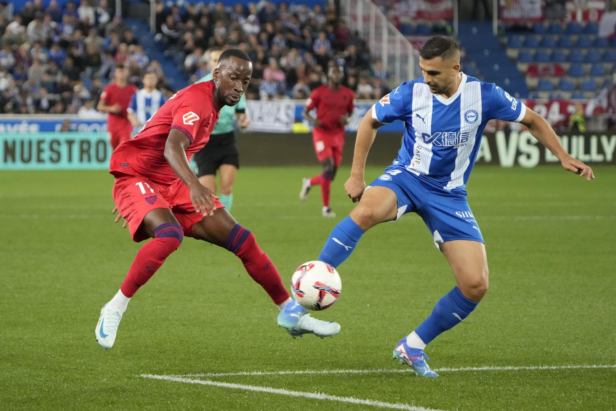 VITORIA-GASTEIZ, 20/09/2024.- El defensa serbio del Alavés Aleksandar Sedlar (d) disputa un balón ante el delantero belga Dodi Lukebakio del Sevilla, durante el partido de la jornada 6 de LaLiga EA Sports, entre el Deportivo Alavés y el Sevilla FC que se disputa este viernes, en el estadio de Mendizorrotza de Vitoria-Gasteiz. EFE/ Adrián Ruiz Hierro